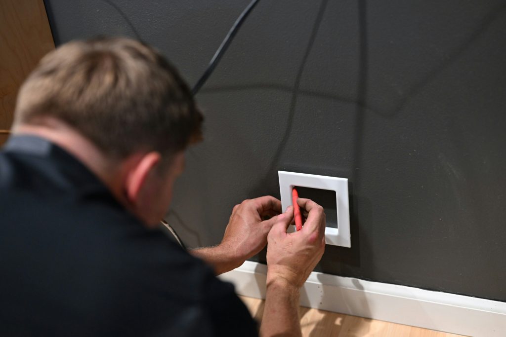 Persona instalando dispositivo domótico en pared siguiendo tutorial paso a paso